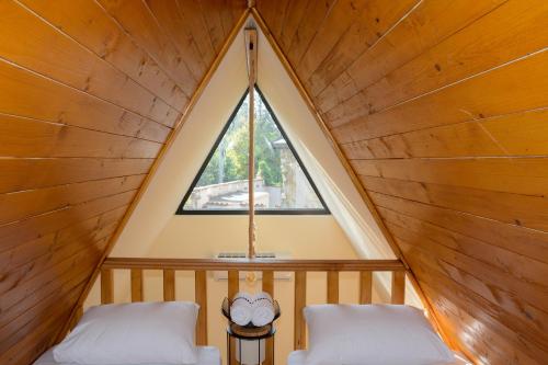two beds in a triangular room with a window at Hotel Marina OASA in Grocka
