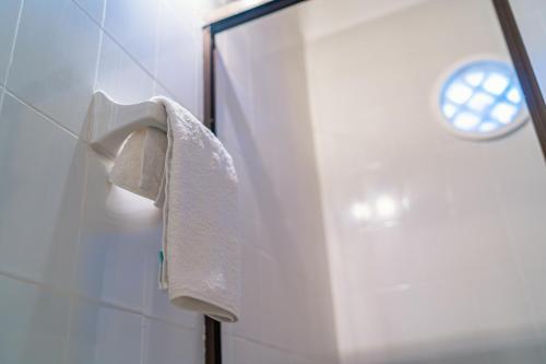 a white towel hanging on a wall in a bathroom at Hotel Cocoliso Island Resort in Isla Grande