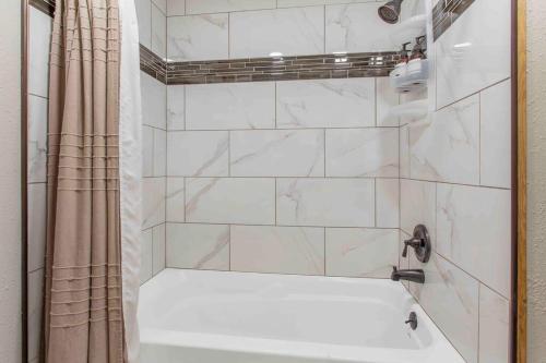 y baño blanco con bañera y ducha. en Stylish Uptown Butte Condo - 632 en Butte