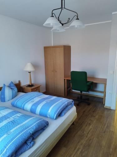 1 dormitorio con 1 cama con escritorio y silla en pension-Zur alten Bäckerei, en Golßen