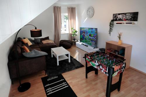 a living room with a couch and a table at Goldhouse - Sauna, Whirlpool, Switch, Darts & mehr in Andernach