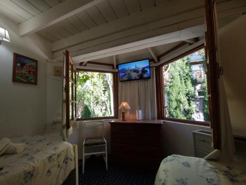 1 dormitorio con 2 camas y 2 ventanas en Holiday Home Las Retamas en San Martín de los Andes