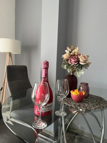 - une table en verre avec une bouteille de vin et 2 verres dans l'établissement Stella LUX Apartment, à Nova Pazova