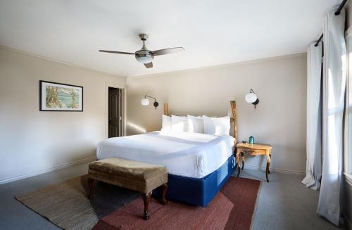 a bedroom with a large white bed and a table at Black Bear Lodge in South Lake Tahoe