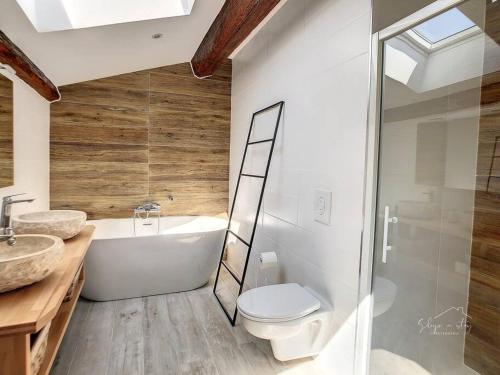 a bathroom with a tub and a toilet and a sink at Hidden Oasis - Maison de caractère avec piscine in Azille
