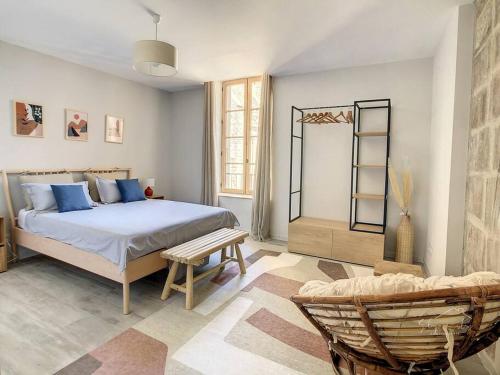1 dormitorio con 1 cama grande y 1 silla en Hidden Oasis - Maison de caractère avec piscine, en Azille