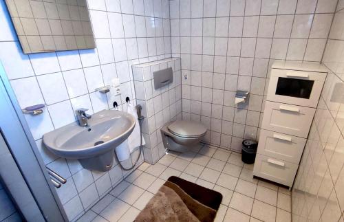 La salle de bains blanche est pourvue d'un lavabo et de toilettes. dans l'établissement Ferienwohnung Ruhequell, à Königsfeld im Schwarzwald
