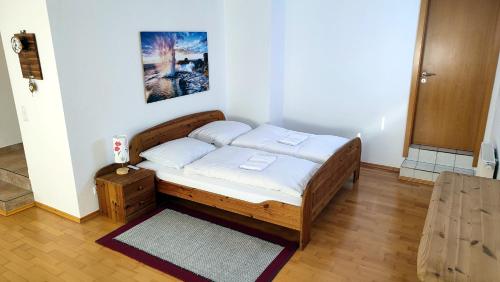 - une chambre avec un lit en bois dans l'établissement Ferienwohnung Ruhequell, à Königsfeld im Schwarzwald