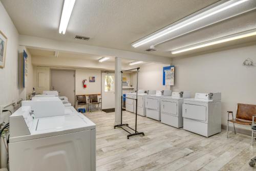 a laundry room with white washers and dryers at New Smyrna Beach Condo Pool Access, Walk to Beach in New Smyrna Beach