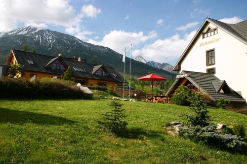 a building with a grass field in front of a house at Reitmayer in Vysoke Tatry - Novy Smokovec