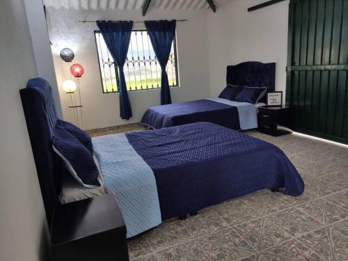 een slaapkamer met 2 bedden en een raam bij Yinkana Casa Campestre in Guatavita