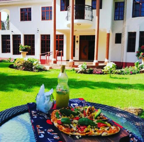 a table with a plate of food and a bottle at Kilimanjaro Pazuri Villas in Moshi