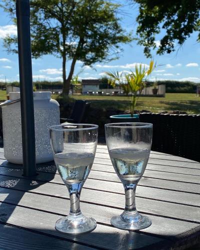 two wine glasses sitting on top of a table at Gites Le Grand Tornage in Évaux-les-Bains
