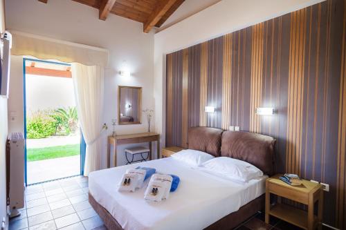 a bedroom with a bed with two towels on it at Villa Givera in Giannoudi