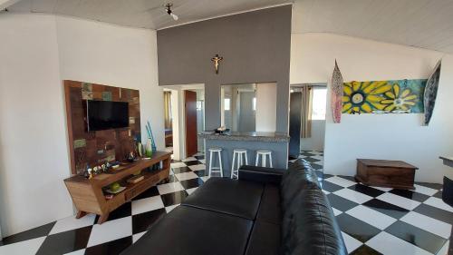 uma sala de estar com um sofá e um piso em xadrez em Cobertura a 200m da Praia de Ponta das Canas em Florianópolis