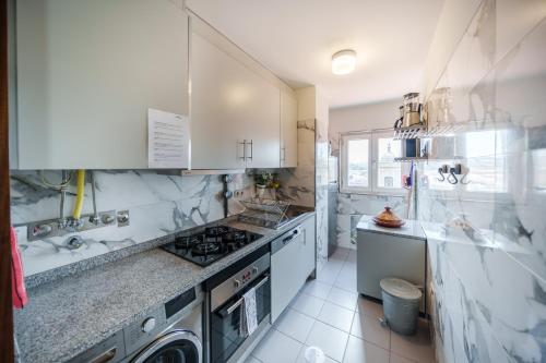 a kitchen with a stove and a washer and dryer at OX Apartments Taipas in Porto