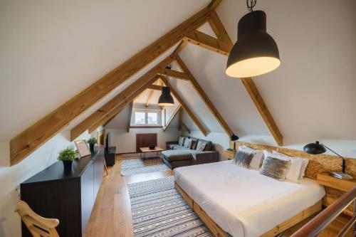 an attic bedroom with a bed and a living room at OX Apartments Taipas in Porto
