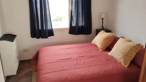 un divano rosso in una stanza con finestra di Las Condalias a Puerto Madryn