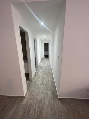 an empty hallway with white walls and wood floors at Rivadavia Deluxe in Mariano J. Haedo