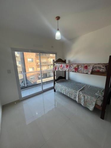 a living room with two beds and a large window at Rivadavia Deluxe in Mariano J. Haedo