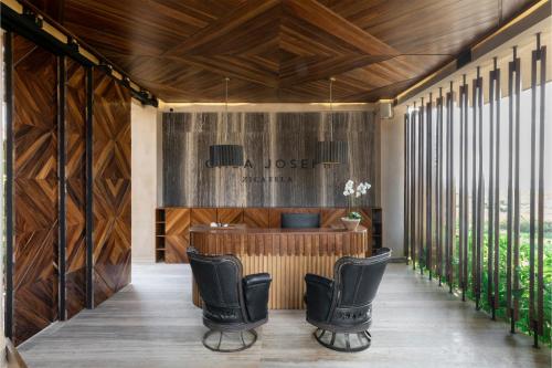 a lobby with wood paneling and black leather chairs at Casa Joseph Zicatela - Adults Only in Puerto Escondido