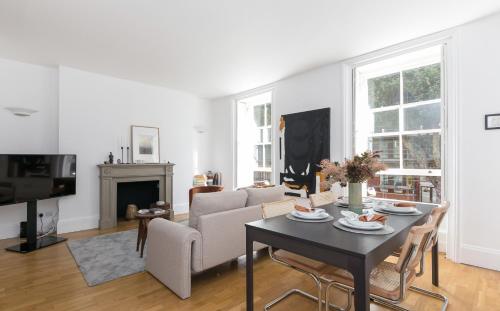 a living room with a table and a couch at Generously large 1 bedroom apartment in Farringdon in London