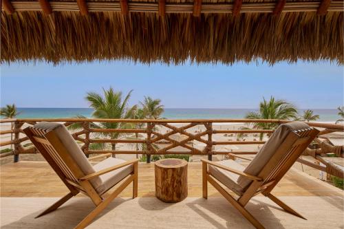 - deux chaises assises sur une terrasse avec vue sur la plage dans l'établissement Casa Joseph Zicatela - Adults Only, à Puerto Escondido