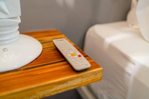 a remote control on a wooden table next to a bed at Hotel Cocoliso Island Resort in Isla Grande