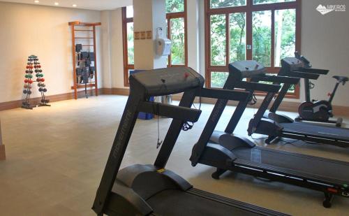 a gym with several tread machines in a room at Vista Azul Suites in Vítor Hugo
