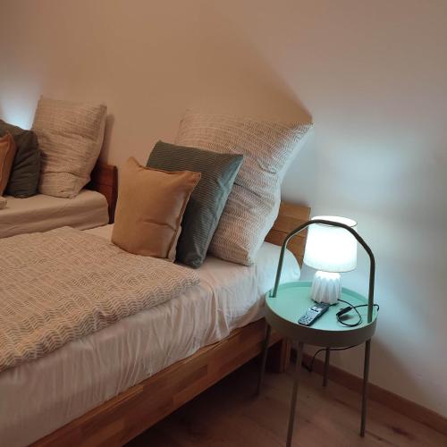 ein Bett mit Kissen und einer Lampe auf einem Tisch in der Unterkunft Praktisch und Gut in der Goldstadt in Pforzheim