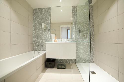 a bathroom with a tub and a sink and a shower at Domaine Santa Giulia Palace in Porto-Vecchio