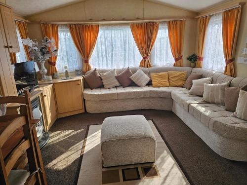 a living room with a couch and a table at Liberty Caravan Hire in Chapel Saint Leonards