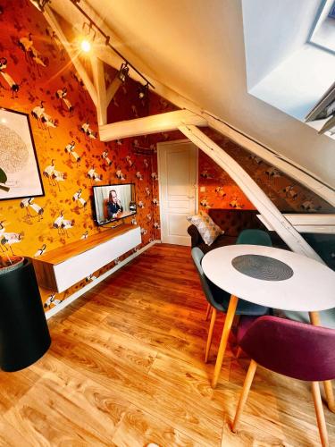 une salle à manger aux murs orange avec une table et des chaises dans l'établissement Appartement T2 Quartier calme / Parking Gratuit, à Saint-Julien-les-Villas