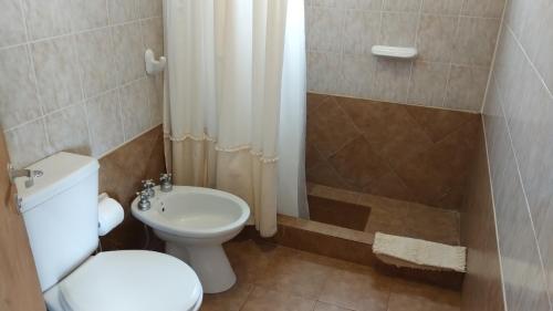 a bathroom with a white toilet and a shower at Las Condalias in Puerto Madryn