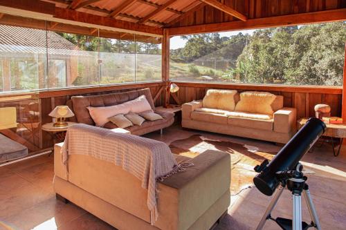 a large living room with a camera on a tripod at Chácara Caminho das Águas in Piraquara