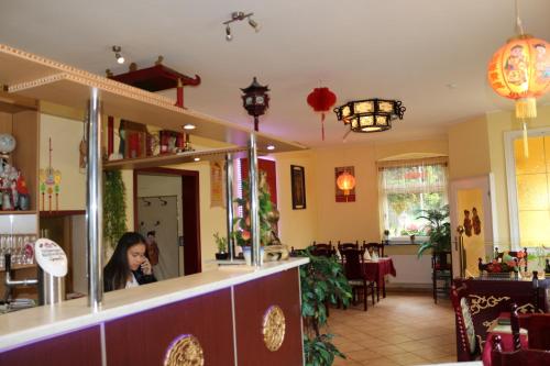 a woman sitting at the counter of a restaurant at Hotel Alte Post in Bad Sooden-Allendorf