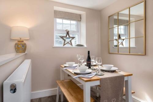 a dining room with a table and a mirror at Seagrass Cottage - Aberdovey in Aberdyfi