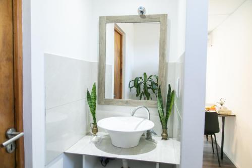 Un baño con un lavabo blanco y un espejo. en Bello Dpto, 20 minutos al Estadio Kempes, cerca de Quality, Hospital Privado, en Córdoba