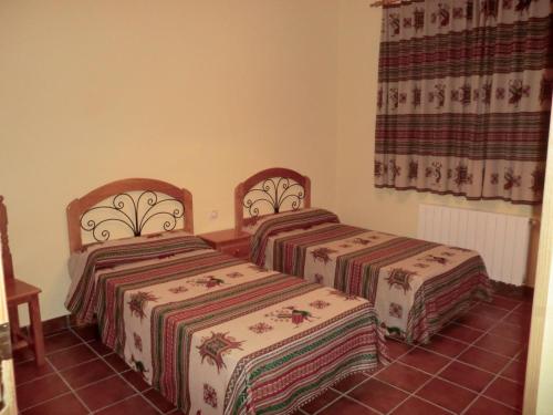 duas camas sentadas uma ao lado da outra num quarto em Apartamentos Rurales El Tormagal 
