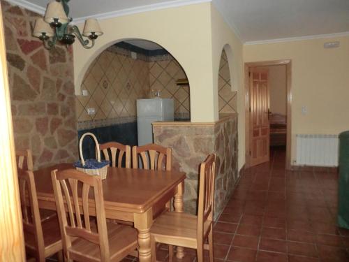 cocina y comedor con mesa y sillas en Apartamentos Rurales El Tormagal, 