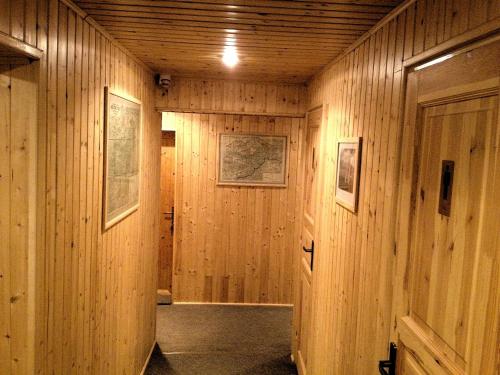 a hallway with wood paneled walls and a door at Horský hotel Portáš in Nový Hrozenkov