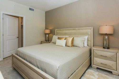 a bedroom with a bed and two night stands with lamps at Gorgeous Apartment at Storey Lake SL47316 in Kissimmee