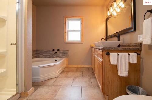 a bathroom with a tub and a sink at The Idaho Lodge & RV Park in Bonners Ferry