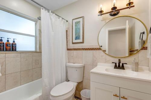 a bathroom with a toilet and a sink and a mirror at Tropical getaway with coastal charm in Pompano Beach