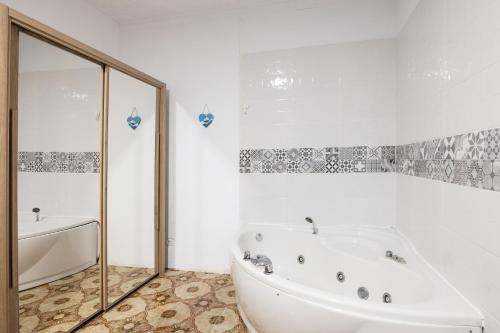 y baño blanco con bañera y ducha. en Kite & Surf Nomad House en Las Palmas de Gran Canaria