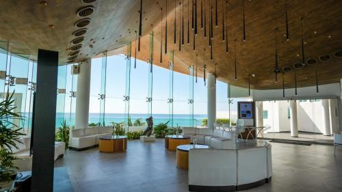 a lobby with a view of the ocean in a building at Oleo Cancun Playa All Inclusive Resort in Cancún
