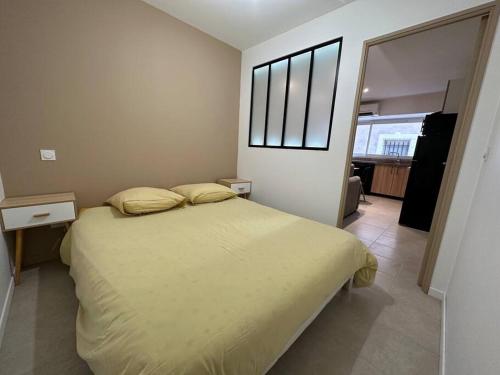 ein Schlafzimmer mit einem Bett und einem großen Fenster in der Unterkunft L’amandier - Appartement in Paulhan