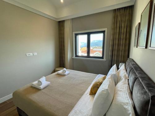 Schlafzimmer mit einem großen Bett und einem Fenster in der Unterkunft Lustica Bay - Centrale 1 Bed Apartment in Tivat