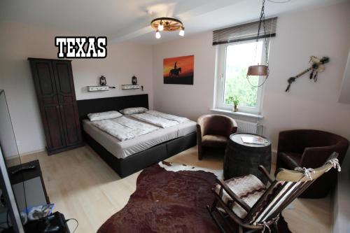 a bedroom with a bed and chairs and a window at Little Hawaii & Texas in Bad Wildungen
