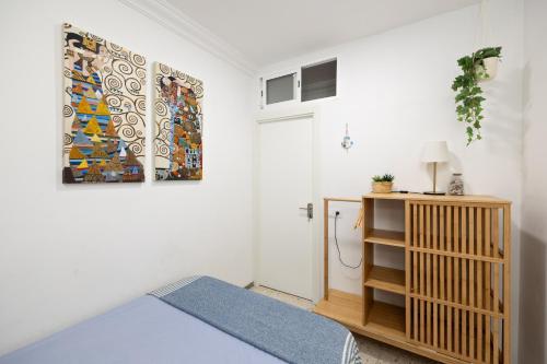 a bedroom with a bed and a painting on the wall at Kite & Surf Nomad House in Las Palmas de Gran Canaria